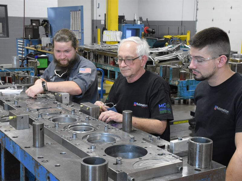 Assembly staff working on metal parts at a manufacturing facility
