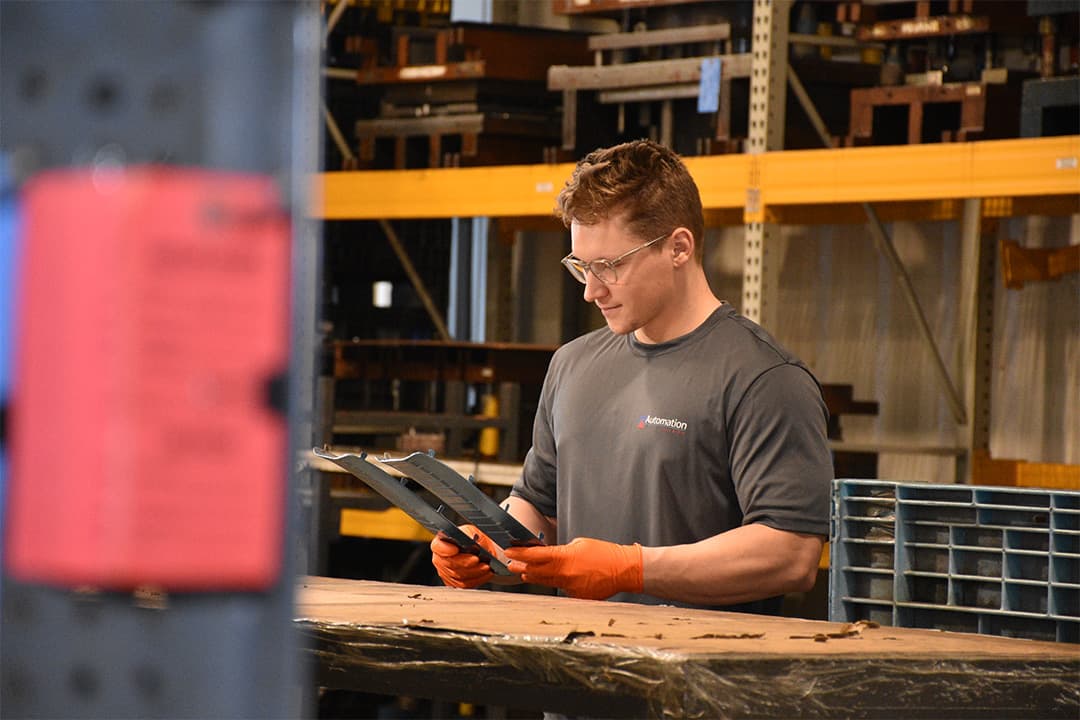 skilled technician inspecting metal stamped part